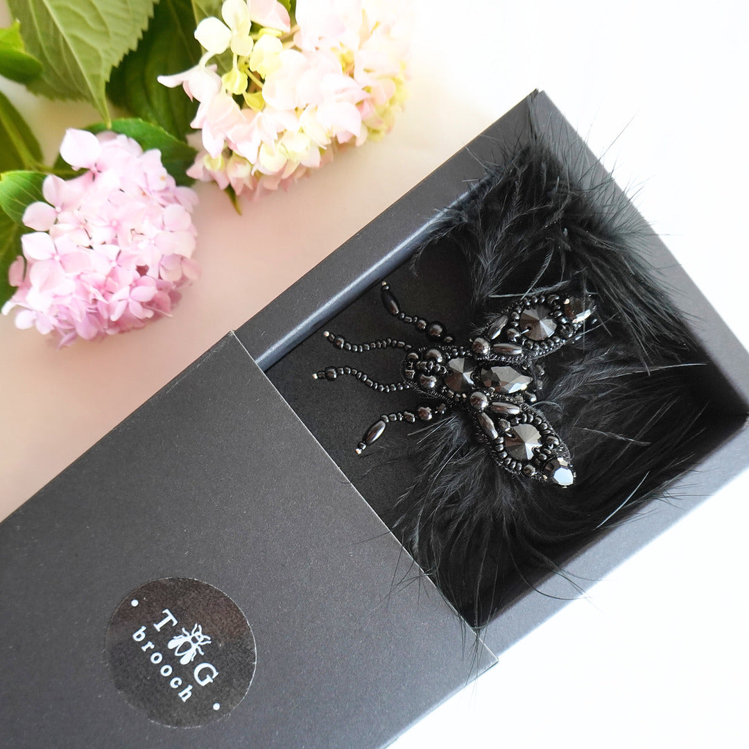 Lovely beaded fly beaded brooch in black color with beads, gemstones and feathers in a TGbrooch box