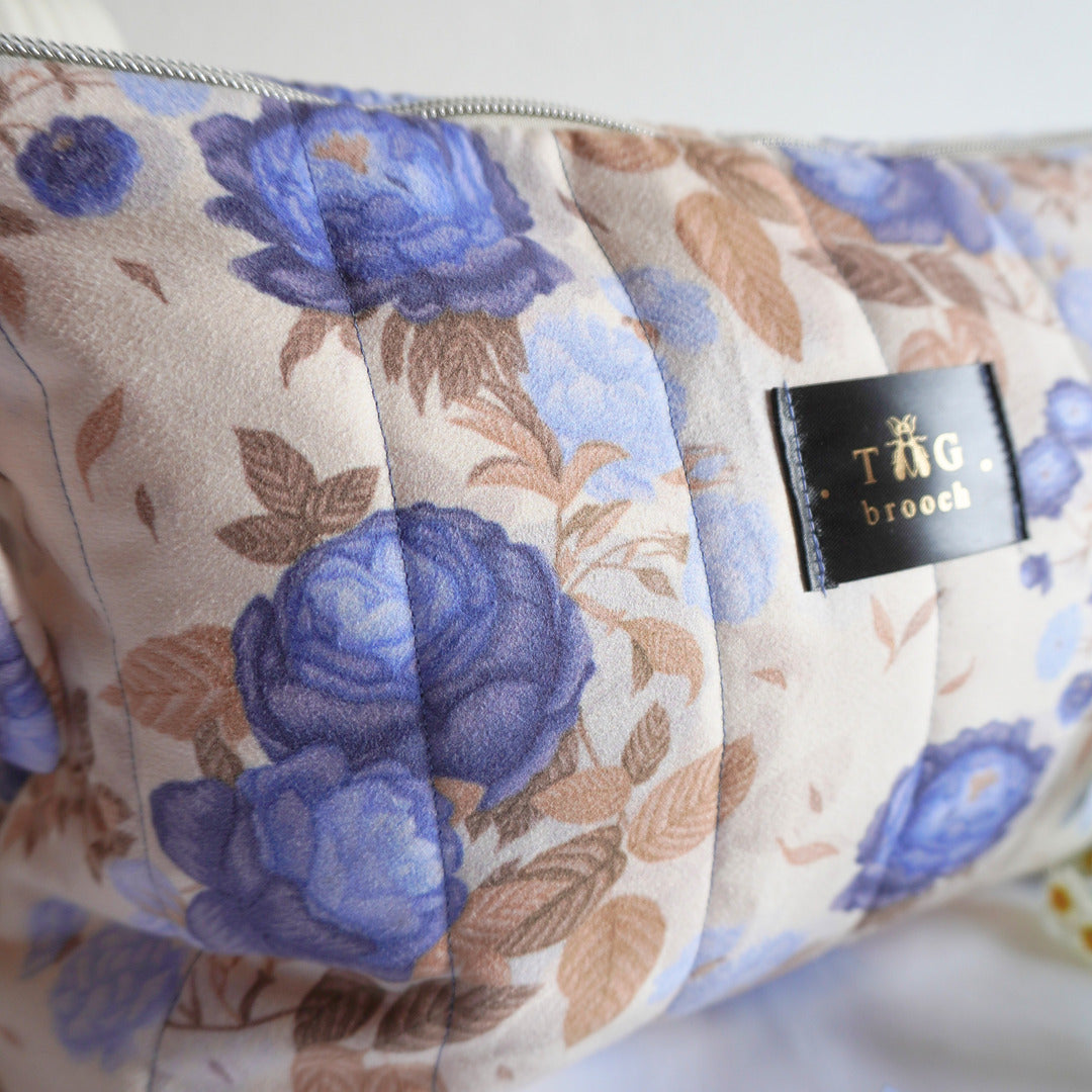 Floral-patterned pouch with blue flowers and beige leaves, featuring a visible TGbrooch tag