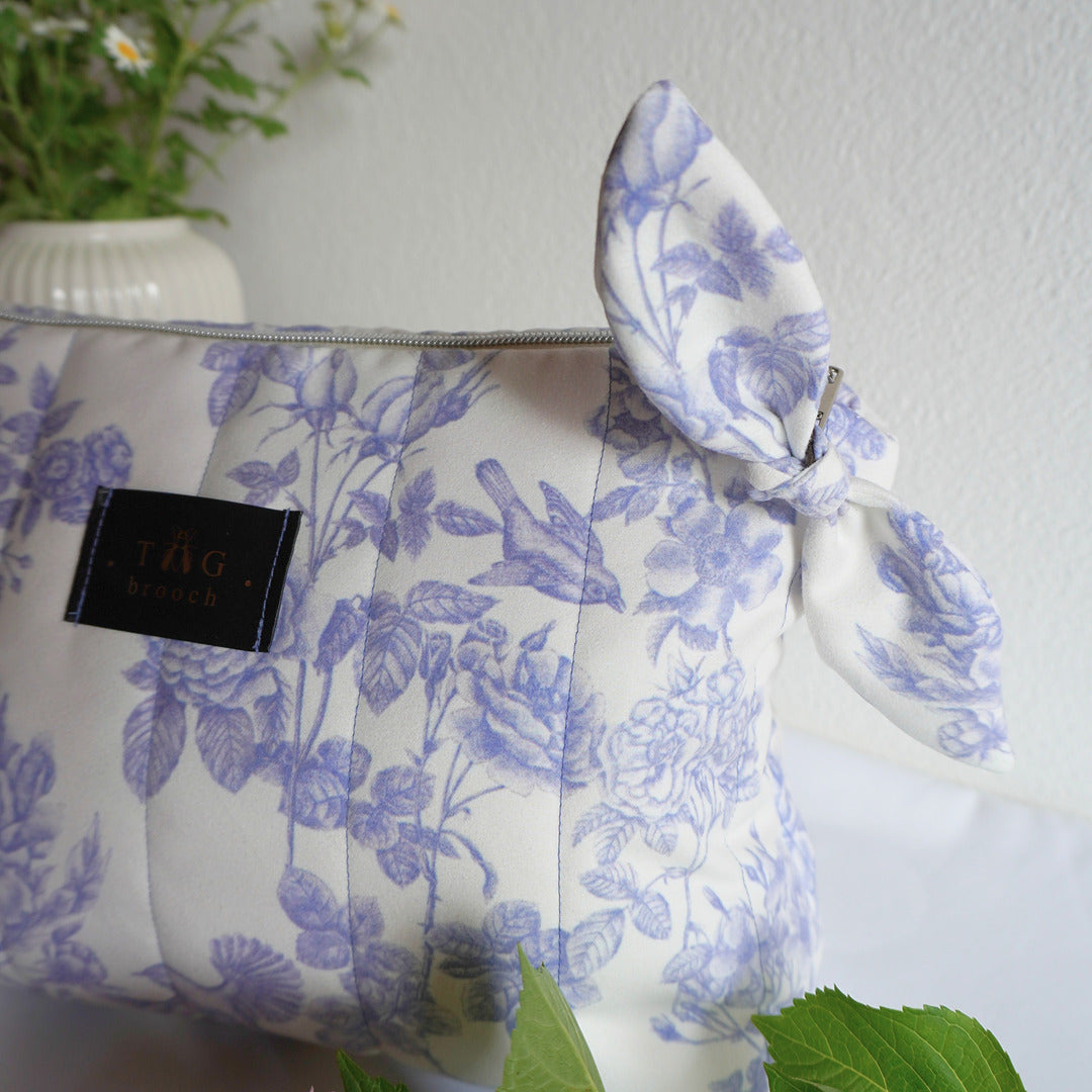 Floral-patterned handmade pouch with a visible brand tag on a light background - TGbrooch