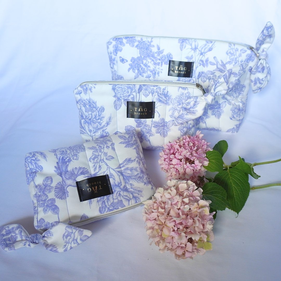 Set of three floral-patterned pouches with a small bouquet of pink flowers on a light blue background - TGbrooch