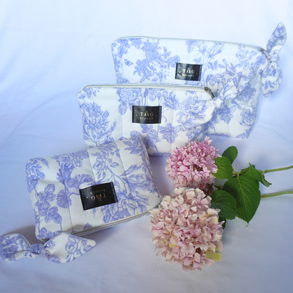 Set of three floral-patterned pouches with a small bouquet of pink flowers on a light blue background - TGbrooch